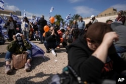 People react at the so-called "Hostages Square" in Tel Aviv, Israel, Feb. 20, 2025, as the bodies of four Israeli hostages, including a mother and her two children, are handed over by Hamas to the Red Cross in Gaza.