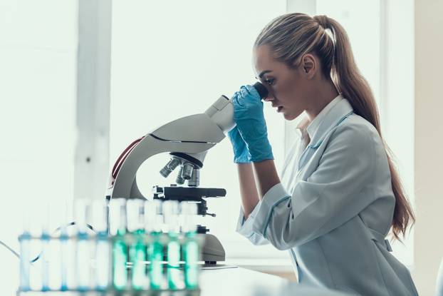 Young Scientist using Microscope in Laboratory