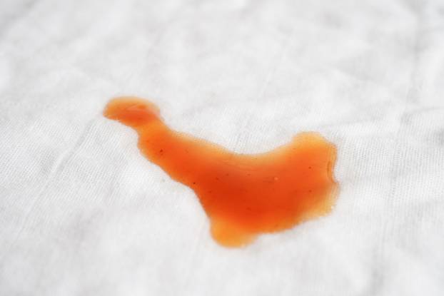 Dirty spicy sauce stain on cloth to wash with washing powder, cl