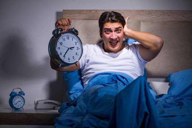 Man having trouble sleeping in bed