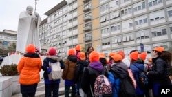 A group of children from a primary school pray for Pope Francis in front of the statue Pope John Paul II outside Agostino Gemelli Polyclinic in Rome, Feb. 19, 2025.