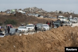 Palestinci čekaju da pređu kontrolni punkt kojim upravljaju američki i egipatski sigurnosni ugovarači nakon što su se izraelske snage povukle sa koridora Netzarim, u blizini grada Gaze, 9. februara 2025.