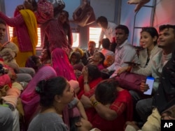 People sit inside a train coach at Prayagraj Junction station while returning after taking a holy dip at the confluence of the Ganges and Yamuna rivers, during the Maha Kumbh festival in Prayagraj, India, on Feb. 18, 2025.