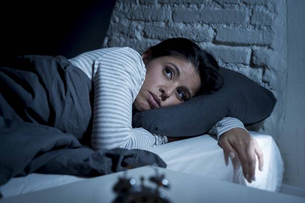 woman in bed late night trying to sleep suffering insomnia