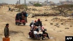 FILE - People ride in the back of a tricycle transporting them from Nuseirat to Gaza City on Feb. 10, 2025 as displaced people return home amid the current ceasefire deal in the war between Israel and Hamas.